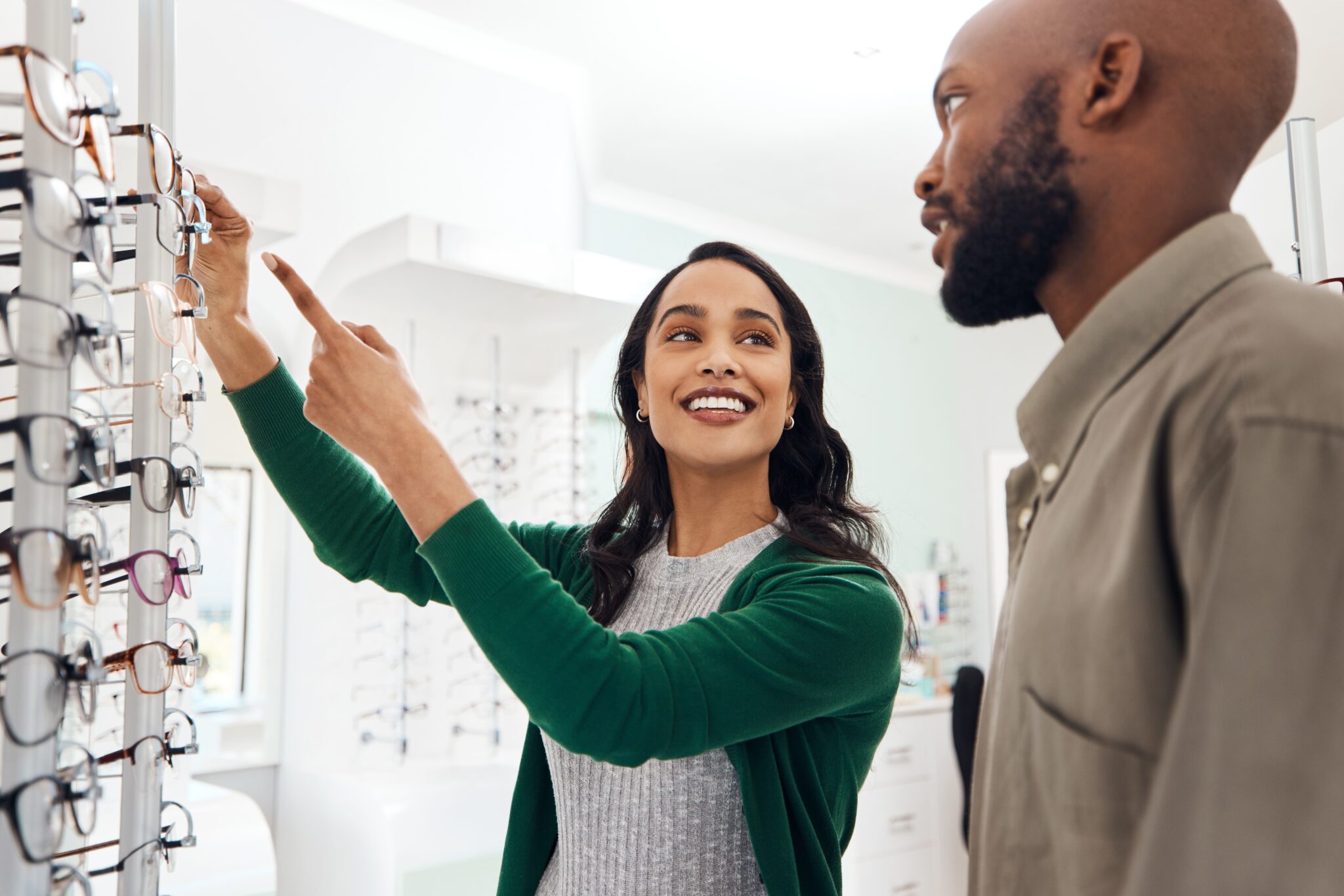 Smiling,Optometrist,Assisting,Man,With,Glasses,In,A,Modern,Sale